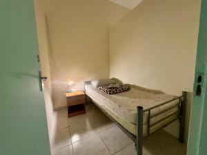 a small bedroom with a bed and a night stand at Backpacker's Bed - No Parking in Abu Dhabi