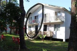 a white house with an arch over the front yard at дома in Grigoleti +1 photo