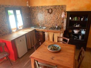 a kitchen with a wooden table with a bowl on it at Ina Maka - Appartamento con giardino immerso nel verde in Mengara +7 photos