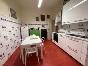 a kitchen with white appliances and a table and chairs at Villetta delle Acacie in Pisa