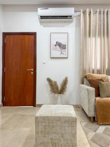 een woonkamer met een bruine deur en een stoel bij Jotis home in Abidjan