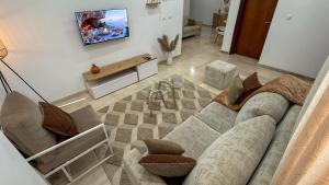 een woonkamer met een bank en een tv bij Jotis home in Abidjan