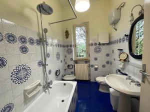 a blue and white bathroom with a tub and a sink at Villetta delle Acacie in Pisa +76 photos