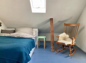 una camera con letto, sedia in legno e sedia di Landhaus von 1836 im Naturpark Schlei a Twedt