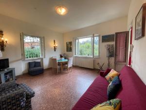 a living room with a purple couch and a table at Villetta delle Acacie in Pisa