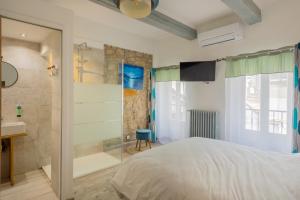 a bedroom with a shower and a bed and a sink at Hôtel restaurant Beauséjour in Berre-des-Alpes