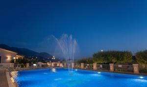 a fountain in a swimming pool at night at Hotel Ristorante Borgo La Tana in Maratea