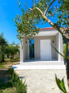 a small white house with a white door at Villa Oliver in Hamallë