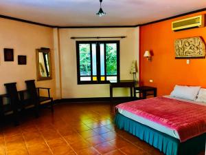 ein Schlafzimmer mit einem Bett und einem Schreibtisch in einem Zimmer in der Unterkunft The Emerald Krabi Beach Resort in Klong Muang Beach