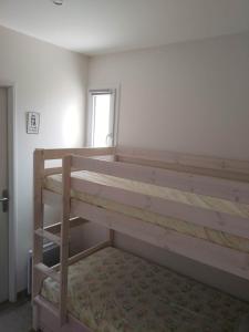 a bedroom with two bunk beds and a window at APPARTEMENT PRES DE ROYAN 7 MINUTES MER CONFORT CALME rdc espace détente jardin in Sémussac