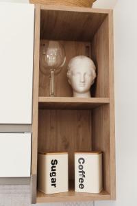 Un estante con un busto y una copa de vino. en Casa Gisa, en Olbia