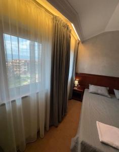 ein Schlafzimmer mit einem Bett und einem großen Fenster in der Unterkunft Daniel's Suite - 4 Season apartment in Bansko