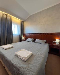 ein Schlafzimmer mit einem großen Bett, auf dem Handtücher liegen in der Unterkunft Daniel's Suite - 4 Season apartment in Bansko