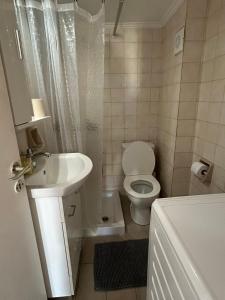 a white bathroom with a toilet and a sink at Moderna Yaya - Andros Chora in Andros