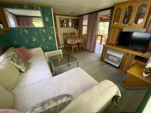 a living room with a couch and a tv at Domki holenderskie na Mazurach in Dźwierzuty