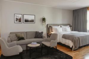 a hotel room with a bed and a couch at Home Hotel Etage in Västerås
