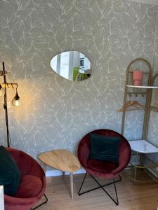 a room with two chairs and a mirror on a wall at Studio cosy hyper centre la Rochelle in La Rochelle