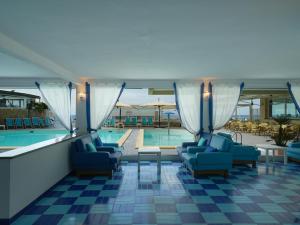 a hotel with a pool and chairs and a swimming pool at Hotel Saline in Palinuro