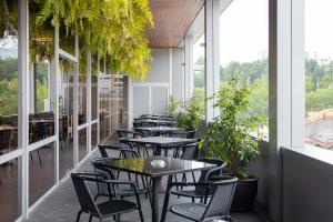 a row of tables and chairs on a balcony with plants at Hotel Navarras in Amarante