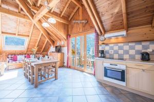 una cocina con techos de madera y una mesa en una habitación en La Mouliniere 1, en Valloire