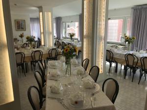 a dining room with tables and chairs with flowers on them at Hotel Ristorante Borgo La Tana in Maratea