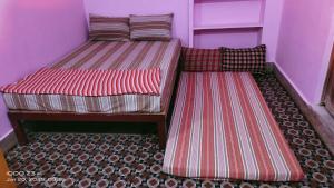 two twin beds in a room with a floor at Shree chendur Rooms stay in Tiruvannāmalai +3 photos