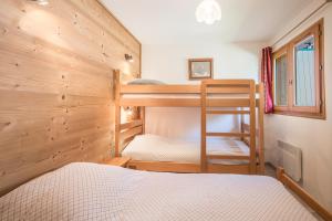 Un dormitorio con dos literas y una ventana. en La mouliniere 2, en Valloire