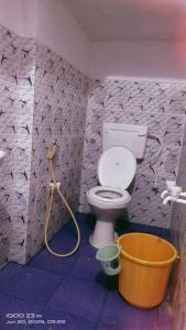 a bathroom with a toilet and a bucket at Shree chendur Rooms stay in Tiruvannāmalai