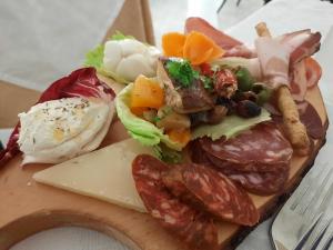 a plate of food with meat and vegetables on a cutting board at Hotel Ristorante Borgo La Tana in Maratea