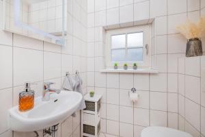 a white bathroom with a sink and a toilet at Haus mit 110qm und Garten 150m zum Wasser in Stralsund +34 photos