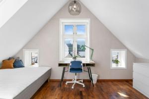 a bedroom with a bed and a desk and a window at Large apartment with 5 bedrooms, 2 bathrooms and roof terrace in Ålesund