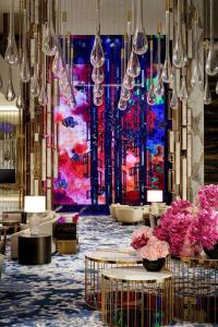 a lobby with tables and chandeliers and a painting at Atlantis The Royal in Dubai