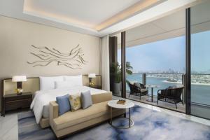 a bedroom with a bed and a couch and a balcony at Atlantis The Royal in Dubai