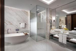 a bathroom with two sinks and a tub and a shower at Atlantis The Royal in Dubai