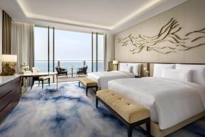 a hotel room with two beds and a desk at Atlantis The Royal in Dubai