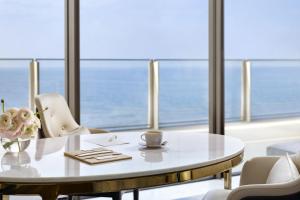 a table and chairs in a room with a view of the ocean at Atlantis The Royal in Dubai