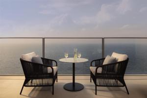 two chairs and a table with wine glasses on a balcony at Atlantis The Royal in Dubai