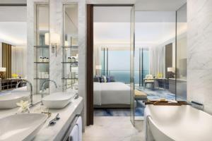 a bathroom with two sinks and a bedroom with a bed at Atlantis The Royal in Dubai