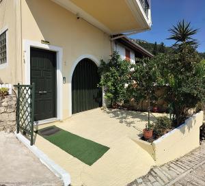 a front door of a house with a green door at House of Aggelos - Karya Lefkadas in Kariá