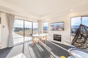 a living room with a table and chairs and a fireplace at Supernova B -2 Bedrooms in Lake Tekapo
