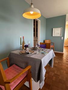 a dining room table with a gray table cloth and a light fixture at Traumhafte See- und Alpensicht in Überlingen +19 photos