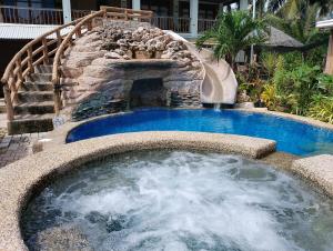 a pool with a water slide in a backyard at La Luna Beach Resort in Guiuan