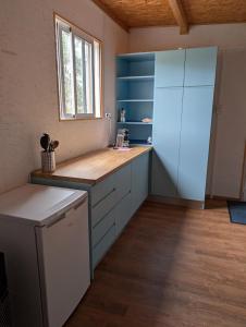 a large kitchen with blue cabinets and a window at Bungalow Quinta Sete Charós in Nisa +23 photos