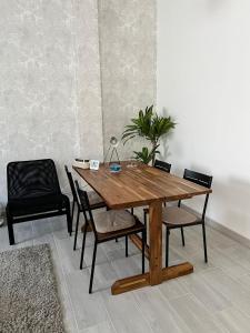 a wooden table and chairs in a room at The Pearl Suite - your stylish cozy and modern flat,in the heart of South Tenerife,just 3 minutes from beach and natural pools in Alcalá +3 photos