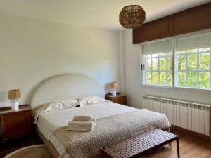 a bedroom with a bed with two towels on it at Casa Santi - 10 minutos de Santiago in Santiago de Compostela