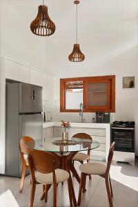 a kitchen with a dining room table and chairs at Chalé Coruja - Taipu com Piscina in Marau