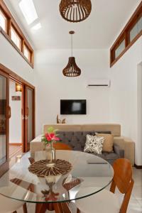 a living room with a glass table and a couch at Chalé Coruja - Taipu com Piscina in Marau