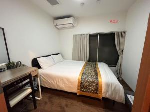 a small room with a bed and a desk and a bed sidx sidx at 花の郷田端a02 in Tokyo