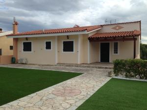 a house with a green lawn in front of it at Terra Relaxa in Loutraki