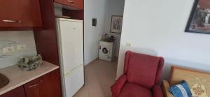 a kitchen with a red chair and a washing machine at Villa Margot in Ksamil